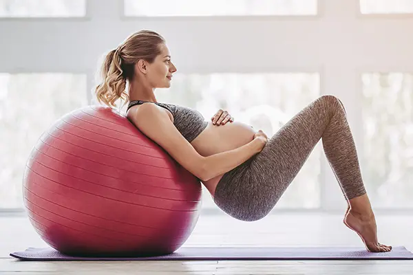 Schwangere Frau nimmt an einem Online-Fitnessworkout teil, das speziell für die Bedürfnisse während der Schwangerschaft konzipiert ist.