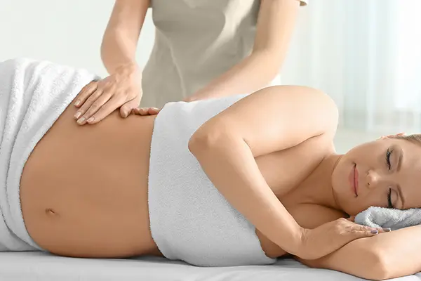 Schwangere Frau genießt eine beruhigende Wellness-Massage, um Verspannungen zu lösen und sich zu entspannen.